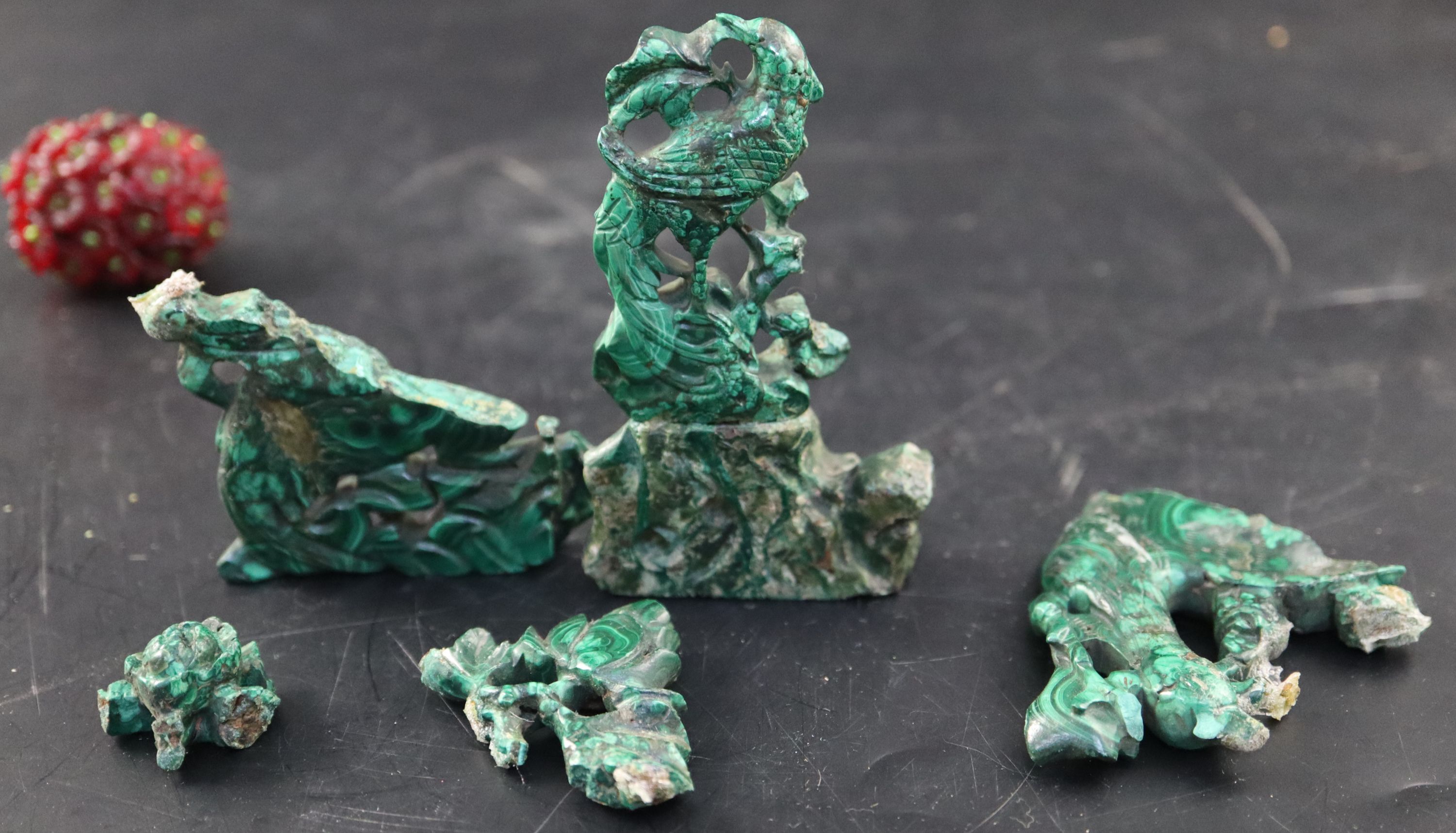 A set of three Chinese carved hardstone figures of immortals, stand; shi shi, malachite fragments etc.